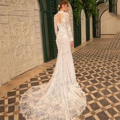 a woman in a white wedding dress standing on a tiled floor next to an archway