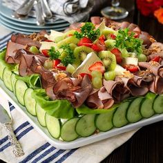 a platter filled with cucumber and fruit