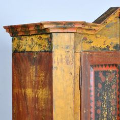 an old wooden cabinet painted yellow and brown