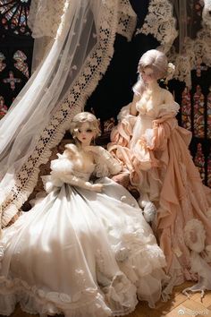 two mannequins dressed in wedding gowns and veils sitting next to each other