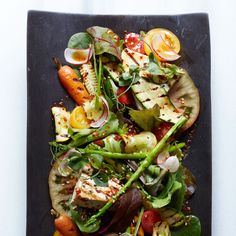 a black plate topped with lots of veggies