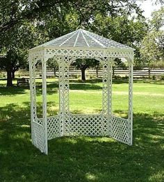 a white gazebo sitting in the middle of a field