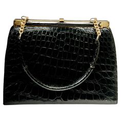 Classic vintage black alligator handbag features gold tone hardware and a single handle attached to the frame with a 5-link chain on each end. The interior is black leather with side compartments and fabric tag marked "Marshall Field & Company", the Chicago department store that retailed it. Very nice vintage condition. Alligator Handbags, Black Alligator, Fabric Tags, Classic Vintage, Vintage Stil, Fashion Handbags, Alligator, Vintage Black, 1960s