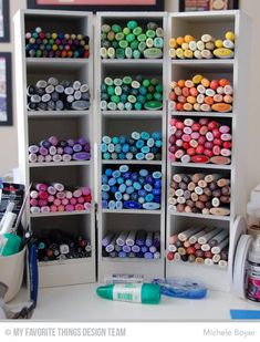 there are many different colored crayons on the shelves in this crafting room