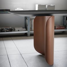 a table that has some kind of curved object on it's base in the middle of a room