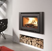 a modern fireplace with logs in the foreground and a red rug on the floor