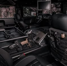 the interior of a vehicle with black leather seats and dashboards, including two monitors