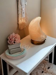 a white table with a lamp on top of it next to a teddy bear and other items