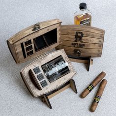 three cigars, two bottles and one box are on the floor next to each other