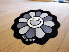 a black and white flower rug with the word omik on it's center