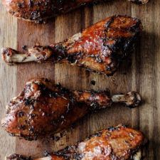 three pieces of meat sitting on top of a wooden cutting board