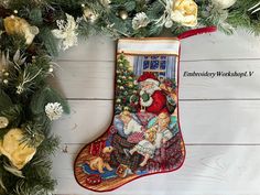 an embroidered christmas stocking hanging from a tree