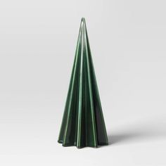 three tall green candles sitting next to each other on a white surface with one candle in the shape of a cone