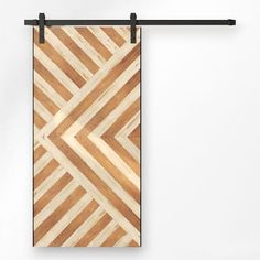 a wooden door hanging on a wall with black metal bars and an abstract wood design