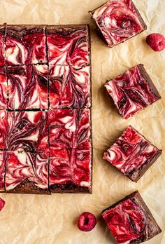 raspberry swirl brownies cut into squares and placed on top of parchment paper