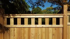 a wooden fence is shown in front of some trees