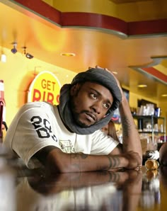 a man sitting at a bar wearing a hat