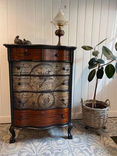 an old dresser has been decorated with intricate designs and is next to a potted plant