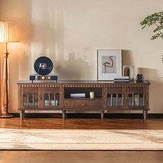 a living room scene with focus on the entertainment center and potted plant in the corner