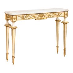 a white marble topped console table with gold accents