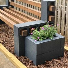 a wooden bench sitting in the middle of a yard next to a flower potted planter