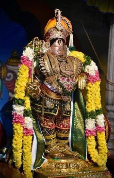 an idol is displayed in front of a wall with flowers and decorations on the sides