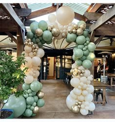 an arch made out of balloons and greenery