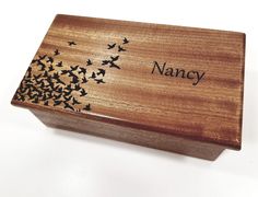 a wooden box with birds on it and the name nancy written in black ink