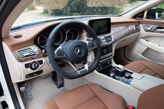 the interior of a car with tan leather seats and steering wheel, dashboard controls, and dash board