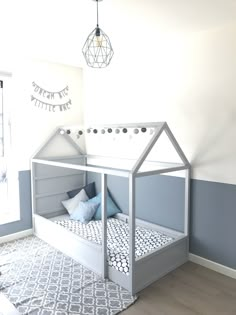 a child's bed in the corner of a room with blue and white walls