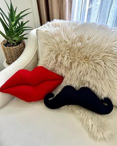 a white couch topped with pillows and a fake moustache