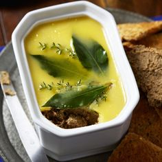 a white bowl filled with soup next to some bread