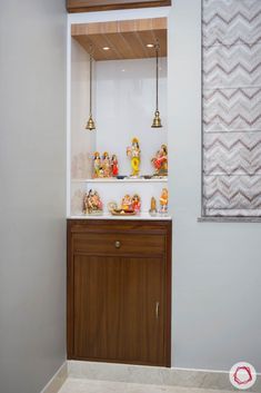 a bathroom with white walls and wooden cabinetry in the corner, along with decorative items on the counter