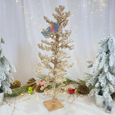 there are three christmas trees with lights on the top and bottom one is decorated in silver tinsel