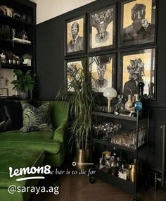 a living room with green couches and pictures on the wall above it, along with plants