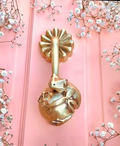 a gold door handle on a pink door