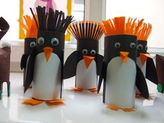 these penguins are made out of toilet paper and have orange mohawks on their heads