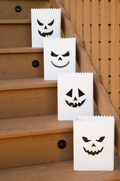 three bags with faces on them sitting on the stairs