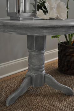 a table with flowers on it and a lantern in the middle, next to a potted plant