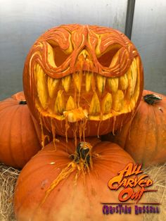 three pumpkins with carved faces on them sitting next to each other in some hay