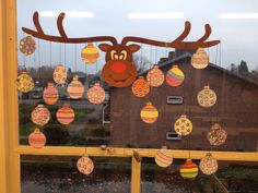 a window decorated with christmas ornaments and a reindeer's head