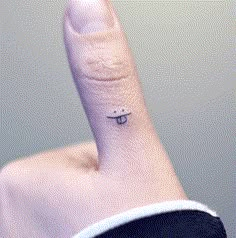 a person's finger with a small tattoo on it