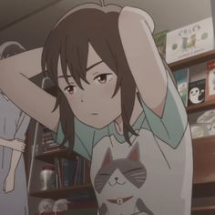 an anime character is holding her head in front of the bookshelf and she's wearing a t - shirt with a cat on it