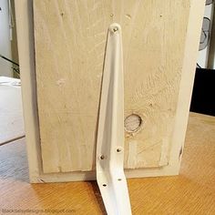 a pair of white scissors sitting on top of a wooden table next to a door