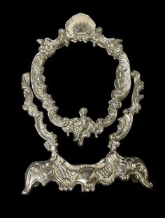 an ornate silver object on a black background