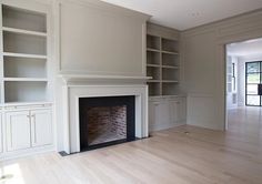 empty living room with fireplace and built - in bookcases