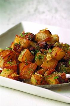 a white plate topped with potatoes covered in seasoning