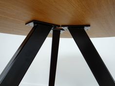 two black metal legs on a wooden table