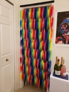 there is a colorful streamer curtain hanging in the room with bottles and champagnes