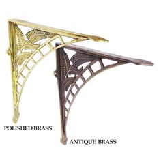 an antique brass plated metal shelf bracket with intricate design on the top and bottom